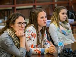 Three students at a long table in class